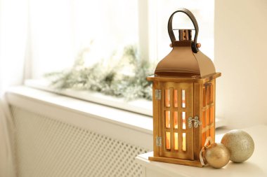 Pencere pervazında yanan mum olan güzel dekoratif Noel feneri. Metin için boşluk