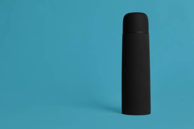 Açık mavi arkaplanda termo şişe, metin için boşluk