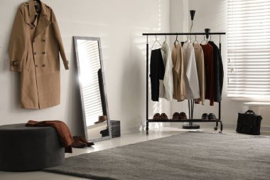 Giysi askısı ve aynası olan bir soyunma odası.