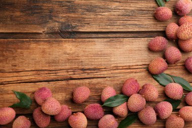 Tahta masada taze olgun liçi meyveleri, düz bir şekilde yatıyordu. Metin için boşluk