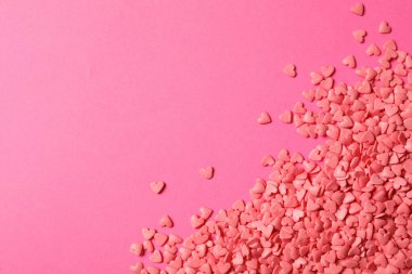 Pembe arka planda kalp şeklinde serpiştirmeler, düz uzanma. Metin için boşluk