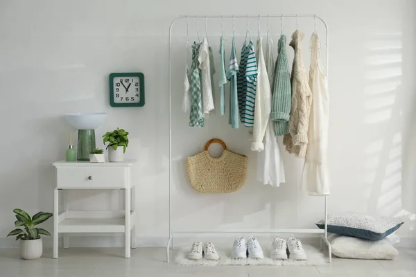 Dressing room interior with clothing rack and nightstand