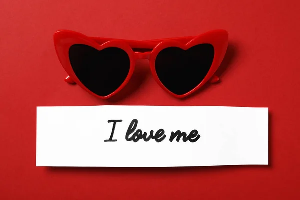 Papier Odręcznym Napisem Love Okulary Przeciwsłoneczne Kształcie Serca Czerwonym Tle — Zdjęcie stockowe