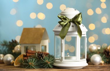 Noel feneri yanan mum ve ahşap masada bulanık ışıklara karşı şenlikli dekor.