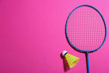 Badminton raketi ve pembe arka planda mekik aleti, düz konum. Metin için boşluk
