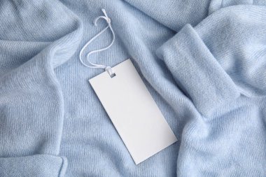 Ilık, mavi kaşmir kazaklı, etiketli, yakın plan.