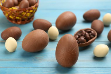 Açık mavi ahşap masada tatlı çikolata yumurtaları