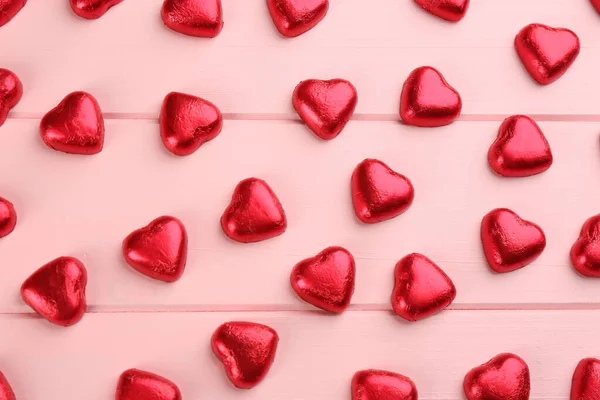 ピンクの木製のテーブルの上にハート型のチョコレートキャンディー フラットレイ — ストック写真