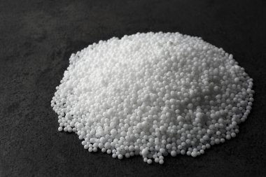 Amonyum nitrat tanecikleri gri masada. Mineral gübresi