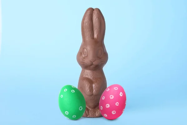 巧克力兔子和彩绘复活节彩蛋浅蓝色背景 — 图库照片