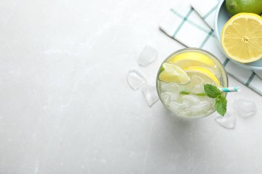 Lezzetli limonatanın düz kompozisyonu soda ve nane şekerli açık gri masa, yazı için yer. Taze yaz kokteyli.