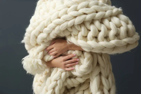 グレーの背景に柔らかいニットの毛布を持っている女性 クローズアップ — ストック写真