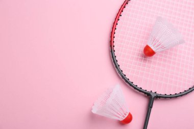 Badminton raketi ve pembe arka planda mekik penisleri, düz yatış. Metin için boşluk