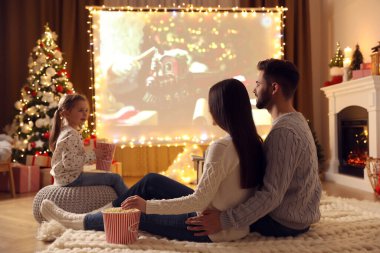 Noel için dekore edilmiş odada projeksiyon ekranında aile filmi izliyoruz. Ev TV ekipmanları