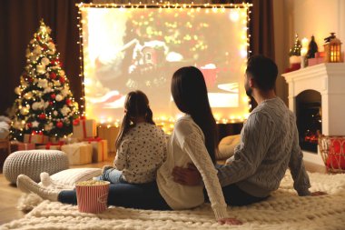 Noel için dekore edilmiş odada projeksiyon ekranında aile filmi izliyoruz. Ev TV ekipmanları