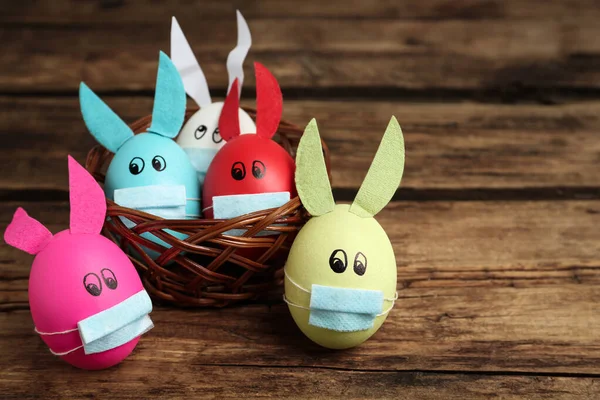 彩绘鸡蛋装饰兔子耳朵和保护面具在木制桌子上 文字空间 Covid 19检疫期间的复活节假期 — 图库照片