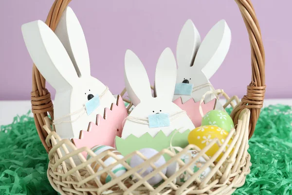 木制兔子 带着防护面具 在纸草的篮子里画鸡蛋 特写镜头 Covid 19检疫期间的复活节假期 — 图库照片