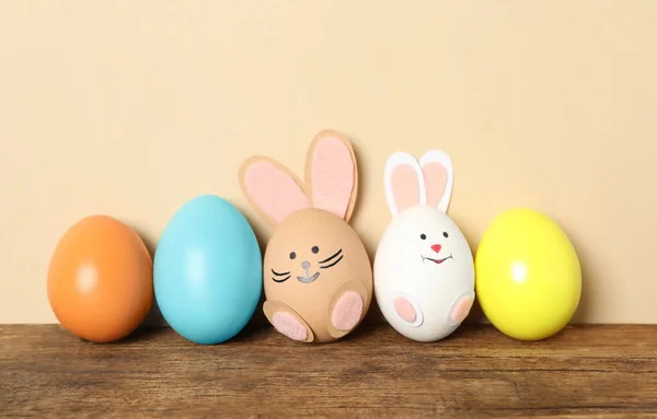两只鸡蛋和其他鸡蛋一样 放在木制桌子上 背景是米黄色的 复活节庆祝活动 — 图库照片