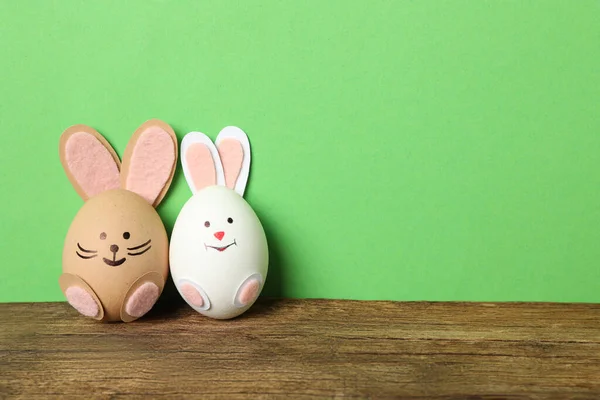 鸡蛋是木制桌子上可爱的兔子 背景是绿色的 有文字的空间 复活节庆祝活动 — 图库照片