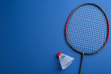 Badminton raketi ve mavi arka planda, dümdüz yatıyordu. Metin için boşluk