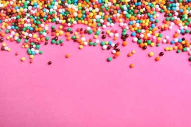 Pembe arka planda parlak renkli serpintiler, metin için yeri olan düz bir yer. Şekerleme dekoru