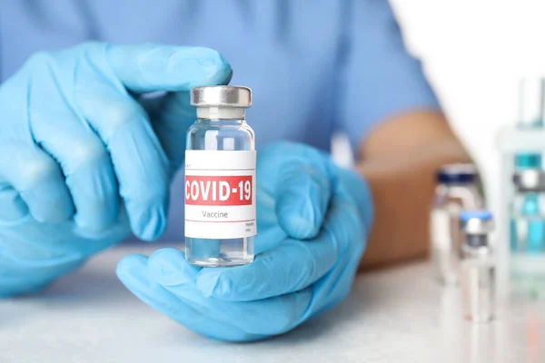 Orvos Covid Elleni Vakcinát Tartalmazó Injekciós Üveget Asztalnál Tartja Közelkép — Stock Fotó