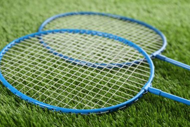 Yeşil çimlerin üzerinde Badminton raketleri, yakın plan.