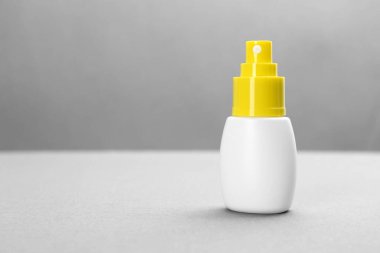 Gri arkaplan üzerinde böcek kovucu sprey olan şişe, metin için boşluk