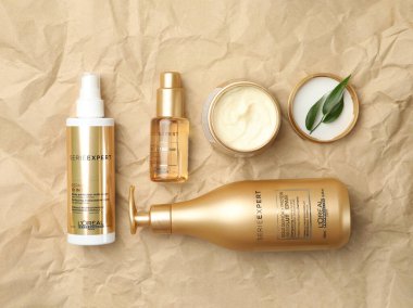 MYKOLAIV, UKRAINE - AĞUSTOS 08, 2020: Buruşuk kağıt üzerinde L 'Oreal saç bakım kozmetik ürünleri ile düz kompozisyon