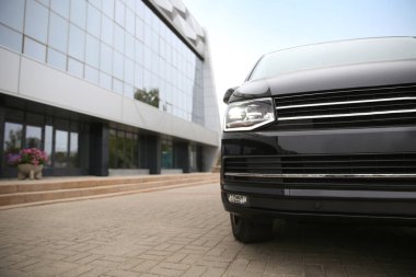 Siyah minibüs binanın yakınına park edilmiş.