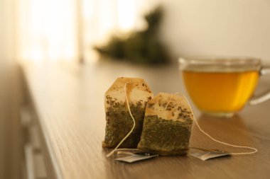 Ahşap masada iki poşet kullanılmış çay.