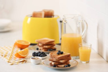 Reçelli kızarmış ekmek ve mutfaktaki beyaz masada taze yaban mersini.