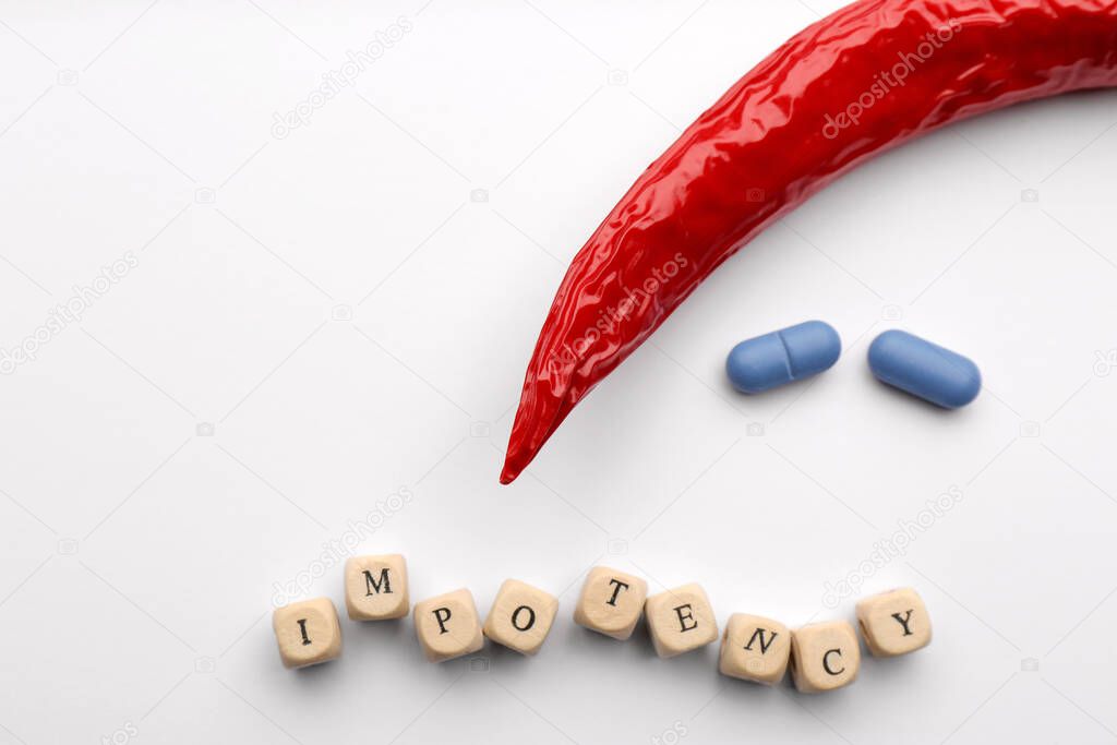 Chili pepper, pills and cubes with word Impotency on white background, flat lay. Space for text