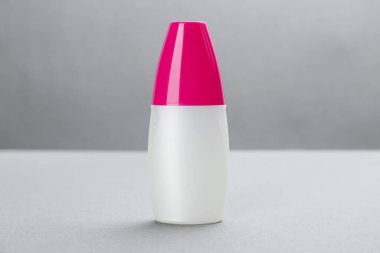 Gri arkaplanda böcek kovucu sprey olan şişe