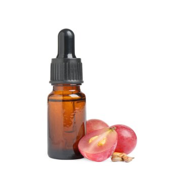 Beyaz arka planda organik kırmızı üzümler, tohumlar ve doğal gerekli yağ şişesi