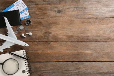 Oyuncak uçakla düz kompozisyon ve tahta arka planda seyahat malzemeleri. Metin için boşluk
