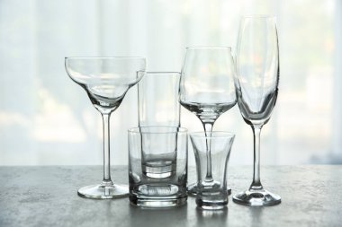 İçerideki gri masada farklı zarif boş bardaklar.