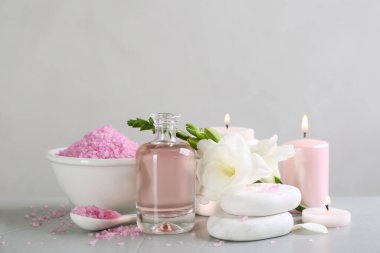 Kaplıca taşları ve açık gri masadaki mumlarla güzel bir kompozisyon.