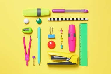 Düz kompozisyon ve sarı zemin üzerinde farklı okul kırtasiyesi