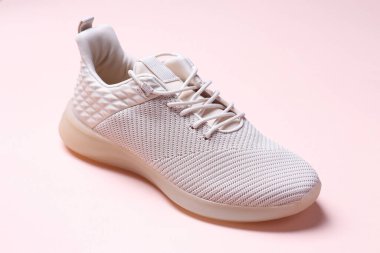 Açık pembe arka planda şık spor ayakkabılar