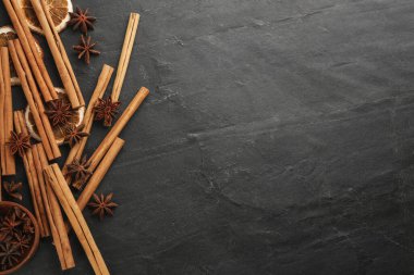 Aromatik tarçın çubukları ve anason siyah masada, düz yerde. Metin için boşluk