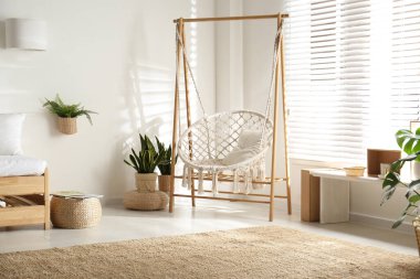 Şık bir odada rahat bir hamak sandalyesi. İç mimari