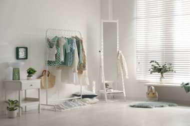 Giysi askısı ve aynası olan bir soyunma odası.