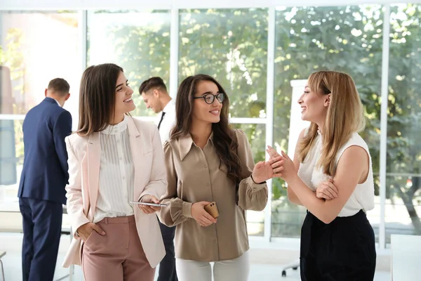 Office employees talking at workplace during break