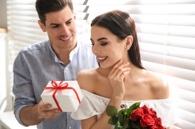 Erkek, evdeki sevgili karısına hediye sunar. Sevgililer Günü kutlaması