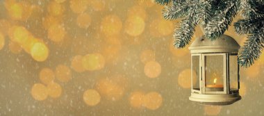 Köknar dalında yanan mum bulunan klasik Noel feneri renk arkaplanına karşı, bokeh etkisi. Metin için boşluk