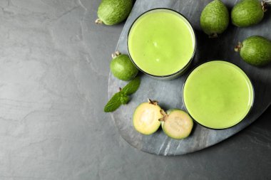 Taze feijoa smoothie ve gri masada taze meyveler. Metin için boşluk