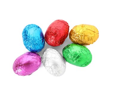 Beyaz arka planda parlak folyoya sarılı bir sürü çikolata yumurtası.