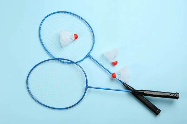 Schläger Und Federhähne Auf Hellblauem Hintergrund Flach Gelegt Badminton Ausrüstung — Stockfoto