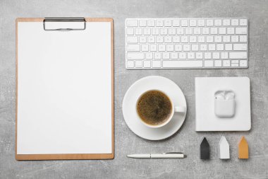 Düz kompozisyon, kahve fincanı, bilgisayar klavyesi gri masada.